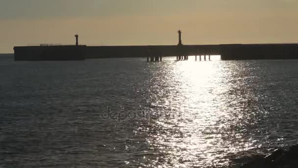 Pier met golven van de zee in zonsondergang verlichting. — Stockvideo