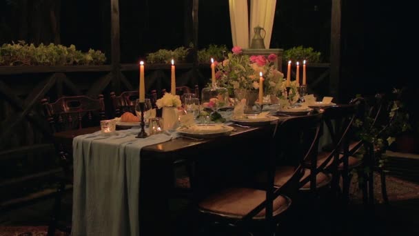 Breda skott av festliga \ semestern bordet med trevlig servering, stolar, trasa, croissant, ljus, mandelbiskvier, blommor (peonys, rosor, lilys av dalen). — Stockvideo