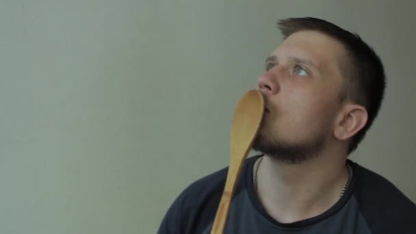 Thoughtful man knocking on his lips with wooden spoon. — Stock Video