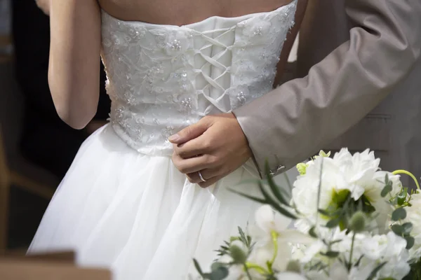 Gelin ve damat el ele tutuşuyorlar.