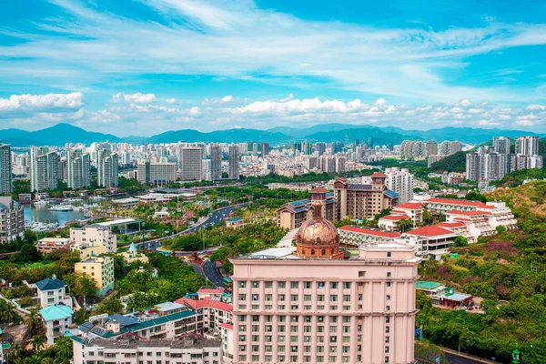 Hainan 'ın Sanya şehrine yukarıdan göz kamaştırıcı bir manzara. Sayısız otel ve apartman manzarası. Uzaktaki Beauty Crown Oteli. Bir sürü hava sahası var. Geniş açı. Hainan, Çin 'de bir cennet adasıdır..