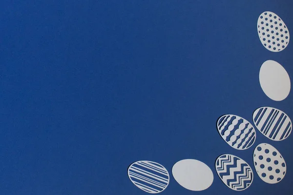 古典的な青の背景に紙からカットイースターの卵 — ストック写真