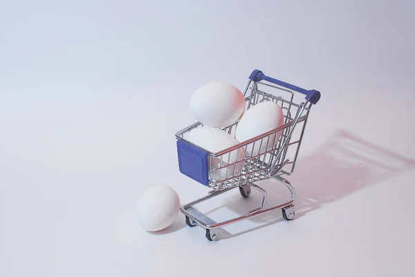 Beyaz arka plandaki ürünler için oyuncak bir vagonda beyaz yumurta..