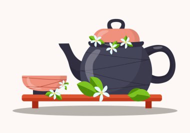 Geleneksel Çin çay seremonisi: bir seramik fincan ve yasemin çiçekli çaydanlık ve çay yaprakları alçak bir ahşap standın üzerinde duruyor.