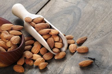 Tahta masadaki kepçedeki bademler.