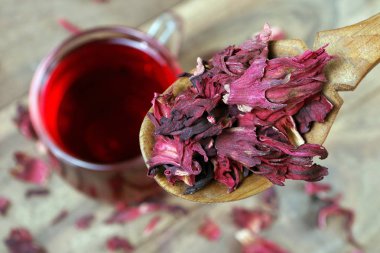 Amfibik çayı. Tahta kaşıkta kuru amber yaprağı. Yaklaş. Bir fincan amberçiçeği çayı..