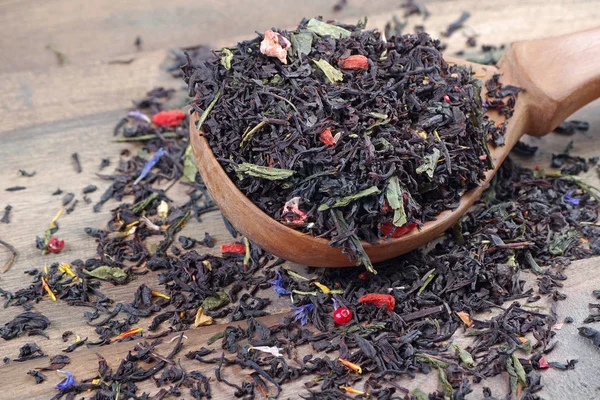 Karışık Çay Tahta Kaşıkta Siyah Çay Kurt Üzümü Yaprakları Kapat — Stok fotoğraf
