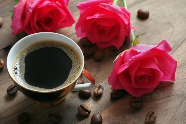 güller ve kahve. kahve fincan ve ahşap bir masa üzerinde gül bir buket.