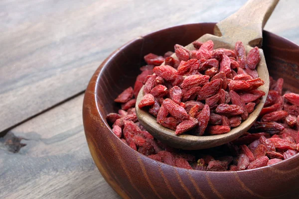 goji berries in a wooden spoon on a bowl close up. weightloss remedy. slimming product. cogoji berries in a wooden spoon on a bowl close up. weightloss remedy. slimming product. copy spacespy spaces