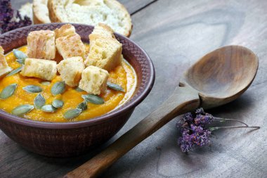 Kabak çorbası tost, kabak tohumu, zencefil ve sarımsak ahşap bir masada. sebze vitamin çorbası. en üstteki görünüm