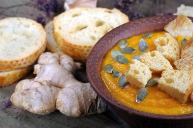 Kabak çorbası tost, kabak tohumu, zencefil ve sarımsak ahşap bir masada. sebze vitamin çorbası. en üstteki görünüm