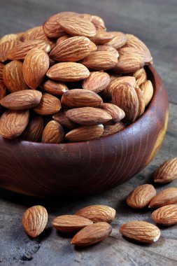 Lanet olsun. Tahta masadaki bir kasede badem. Boşluğu kopyala