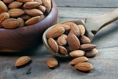 Lanet olsun. Tahta masadaki bir kasede badem. Boşluğu kopyala