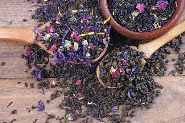 混合茶 红茶和绿茶 有干花瓣和水果 干茶叶放在木制汤匙里 关门了 — 图库照片