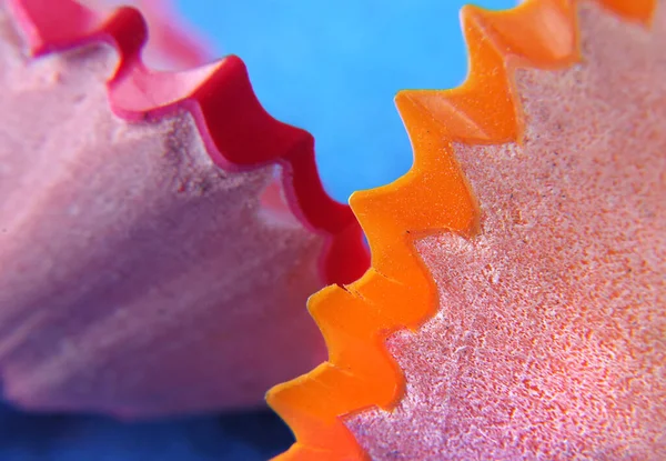 color and shape. shavings of colored pencils. bright red and orange background.