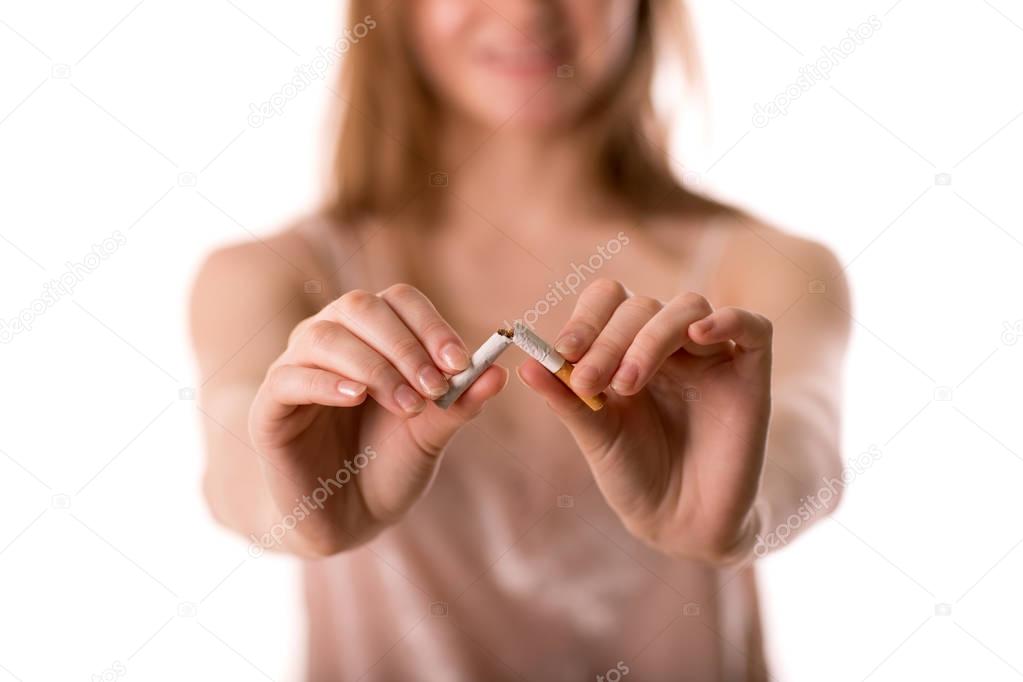 Woman stop smoking and breaks cigarettes in hand, stop addiction