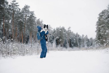 Genç kadın ve sınır köpeği kış ormanında