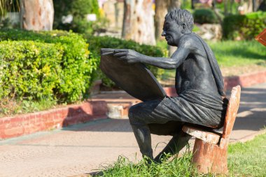 Kemer, Türkiye - 21 Haziran 2018: Kemer, Türkiye 'de gezinti alanında gazete okuyan bir adamın heykeli