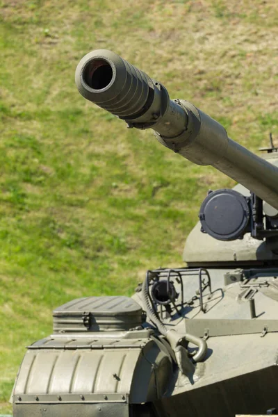 Koyu yeşil kamuflajlı eski bir askeri tank.