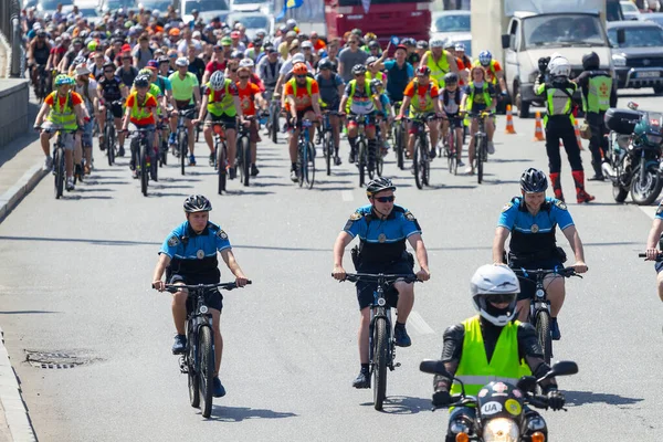 キエフ ウクライナ 2019年6月1日 自転車の警察官は ウクライナのキエフでのアマチュア自転車に乗る自転車のグループをリードしています ストックフォト