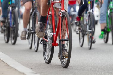 Bir grup insan yolda bisikletle gider.