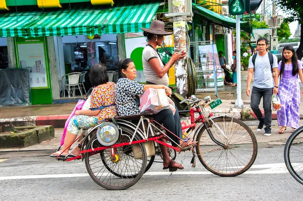 2017年10月21日 两个通勤者骑三轮车 司机看着他的智能手机 而停止在交通灯在十字路口 用三轮车通勤通常是低收入的缅甸 — 图库照片