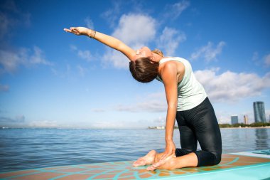 Atletik genç kadın Sup Yoga pratik geri Ala içinde poz viraj 