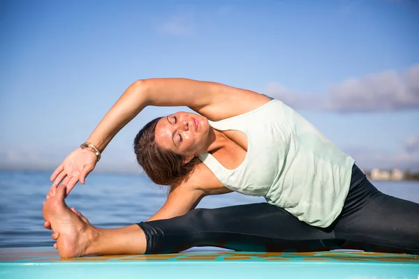 Sup Yoga pratik yan bend atletik genç kadın poz Ala içinde — Stok fotoğraf