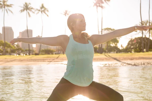Frau macht Sup Yoga in Waikiki bei Sonnenaufgang Kriegerpose — Stockfoto