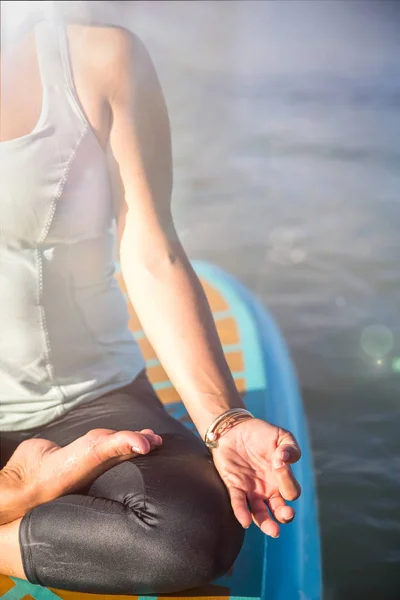 Photo recadrée de la femme en méditation après son Yoga SUP sur le — Photo