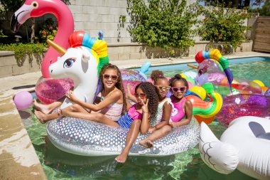 Yaz havuzu partisi, güneş gözlüklü şirin kızlar fotoğraf için poz veriyor.