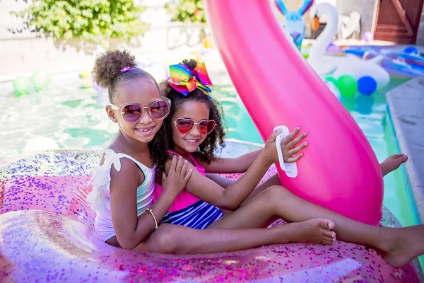 Summer fun cute girls on inflatable flamingo — Stock Photo, Image