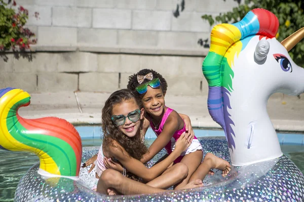 Summer fun cute girls on inflatable unicorn — Stock Photo, Image