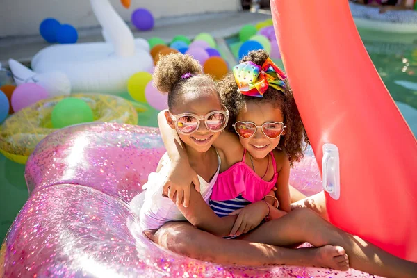 Summer fun cute little girls on inflatable flamingo — Stock Photo, Image