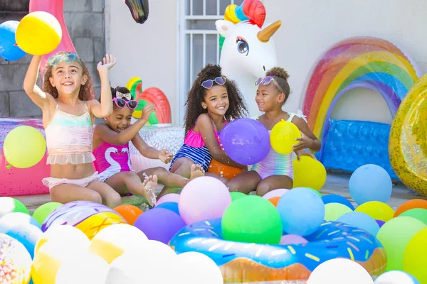 Summer pool party cute girls in sunglasses playing with balloons — ストック写真