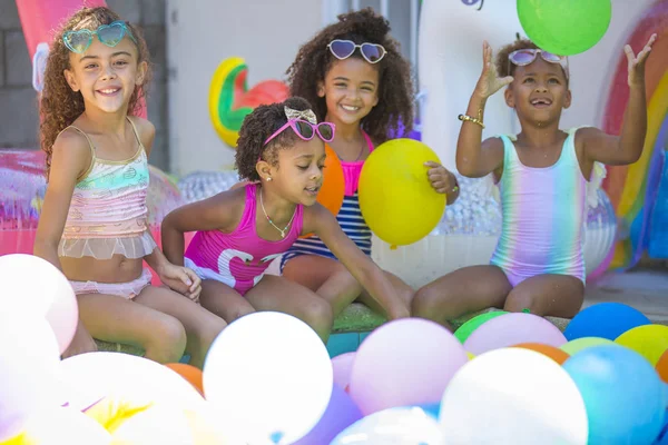 Verão piscina festa bonito meninas em óculos de sol jogando com balões — Fotografia de Stock