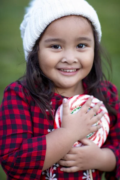 Petite fille mignonne tenant une sucette rayée de canne à sucre — Photo