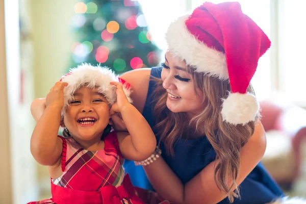 Mor och dotter puttar på julen hattar — Stockfoto