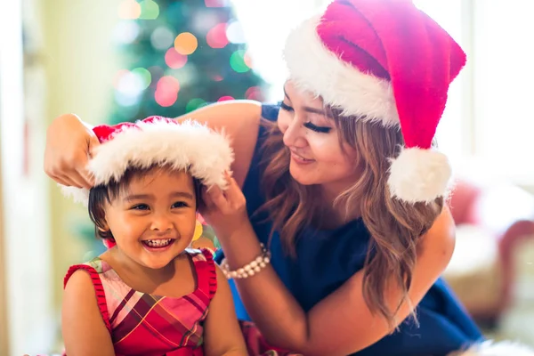 Mãe e jovem filha colocando em chapéus de Natal Fotos De Bancos De Imagens Sem Royalties