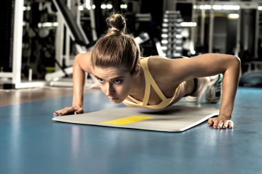 Genç fitness kadın egzersiz press-up yürütmek
