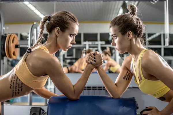 Two young fitness woman, arm wrestling in gym — Stock Photo, Image