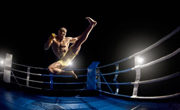 Boxeador tailandés en el ring de boxeo, salto y patadas —  Fotos de Stock