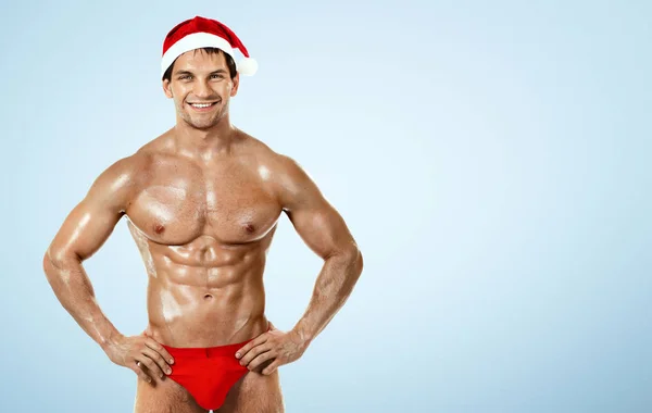 Seksi fitness Noel Baba vücut geliştirmeci mavi zemin üzerine — Stok fotoğraf