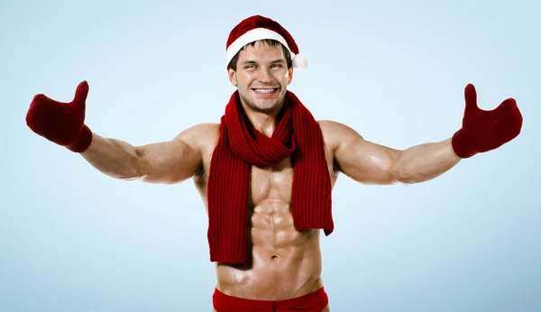 Fitness sexy Babbo Natale in marmitta rossa, sorriso, sul retro blu — Foto Stock
