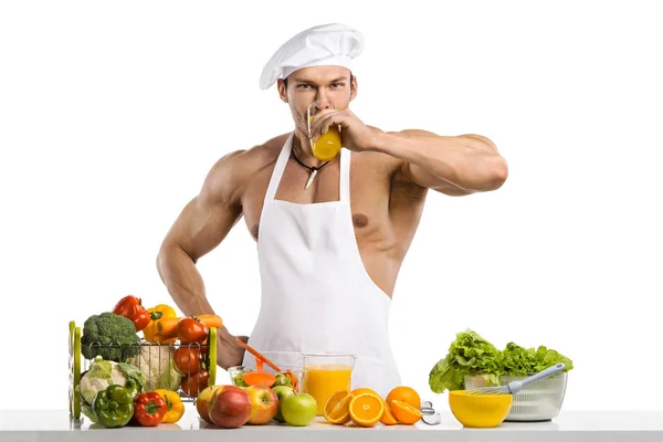 Mannen bodybuilder cook, Matlagning färsk pressad juice och trädg — Stockfoto