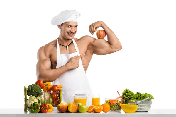Homem fisiculturista cozinhar com maçã no bíceps — Fotografia de Stock