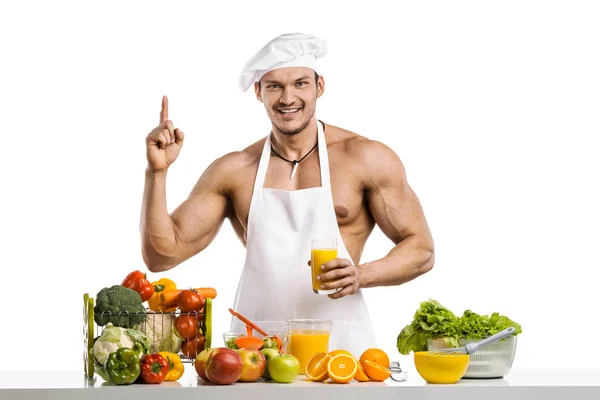 Mannen bodybuilder cook, Matlagning färsk pressad juice och trädg — Stockfoto