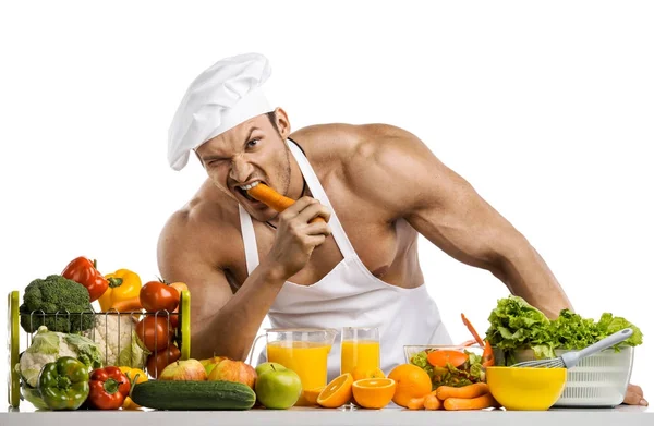 Mann Bodybuilder kochen Karotten zum Nagen, auf weißem Hintergrund, isolat — Stockfoto