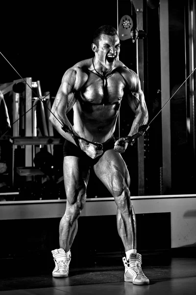 Zeer energie-atletische man bodybuilder, uitvoeren van de oefening met gym c — Stockfoto