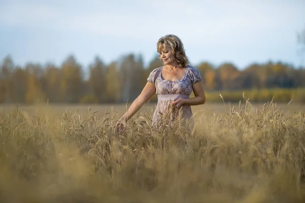 Mature woman in wheat field — Stock Photo, Image